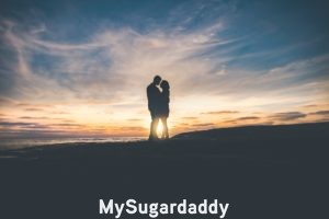 En la imagen se ve una pareja abrazada durante el atardecer. Es el momento de los dos, nadie esta ahi para interrumpir ese momento tan feliz. Debe estar pensando: es la mujer de mi vida. 