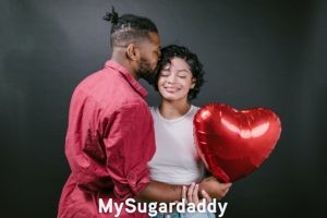 Estar en pareja: Sentirse cercanos Relación nueva: Vemos a un hombre dándole un beso a su pareja. Ella esta feliz y sostiene un globo que tiene una forma de corazón. Estar en una relación significa gozar de este privilegio.