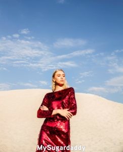 En la foto vemos a una mujer con un vestido rojo y brillante. Es un vestido excepcional. Ella si sabe como vestirse y llamar la atención. 