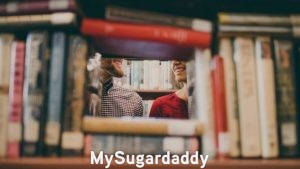 Mentor: Sugar Daddy y Sugar Baby Mentor: Esta imagen muestra a dos personas que están en una biblioteca. Él es el mentor de ella y le enseña las cosas que necesita saber para ser exitosa. Ambos parecen estar felices, ya que, por seguro, son una pareja.