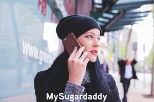 Sugar Baby al teléfono: Sugar Baby haciendo una llamada Sugar Baby al teléfono: En la imagen vemos a una mujer joven haciendo una llamada por teléfono. Parece estar seria o aburrida, por ende, es probable que tenga una conversación incomoda.