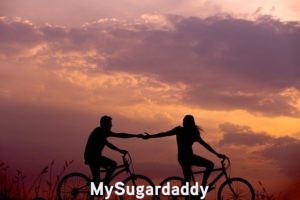 Zona de confort: En la imagen vemos a una pareja andando en bicicleta. Ella le da una mano a el. Es un símbolo de apoyo. Salir de la zona de comodidad es más fácil de esta manera.