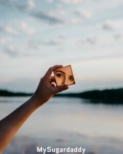 Autorreflexión: Espejo  Autorreflexión: Vemos el reflejo de una mujer en un espejo pequeño. Tiene una mirada sería y parece estar decidida. Al fondo se ve un paisaje bonito. Quizás este tratando conocerse mejor saliendo de la rutina diaria.